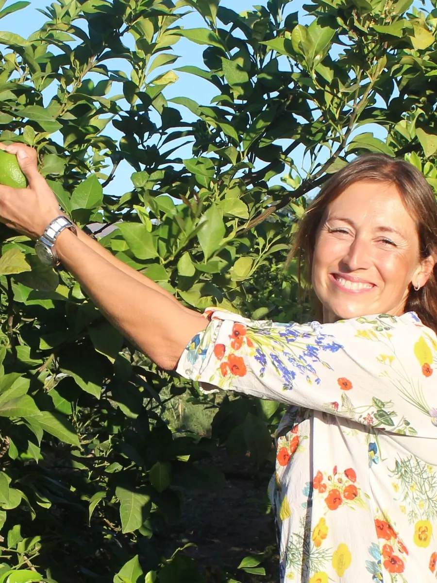 Tina Skalandar picking a lemon from a tree